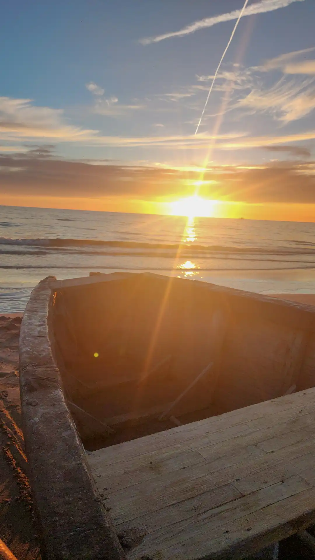 Blick über ein Fischerboot in den Sonnenuntergang über dem Meer. Der Zeitpunkt für Stille und loslassen.