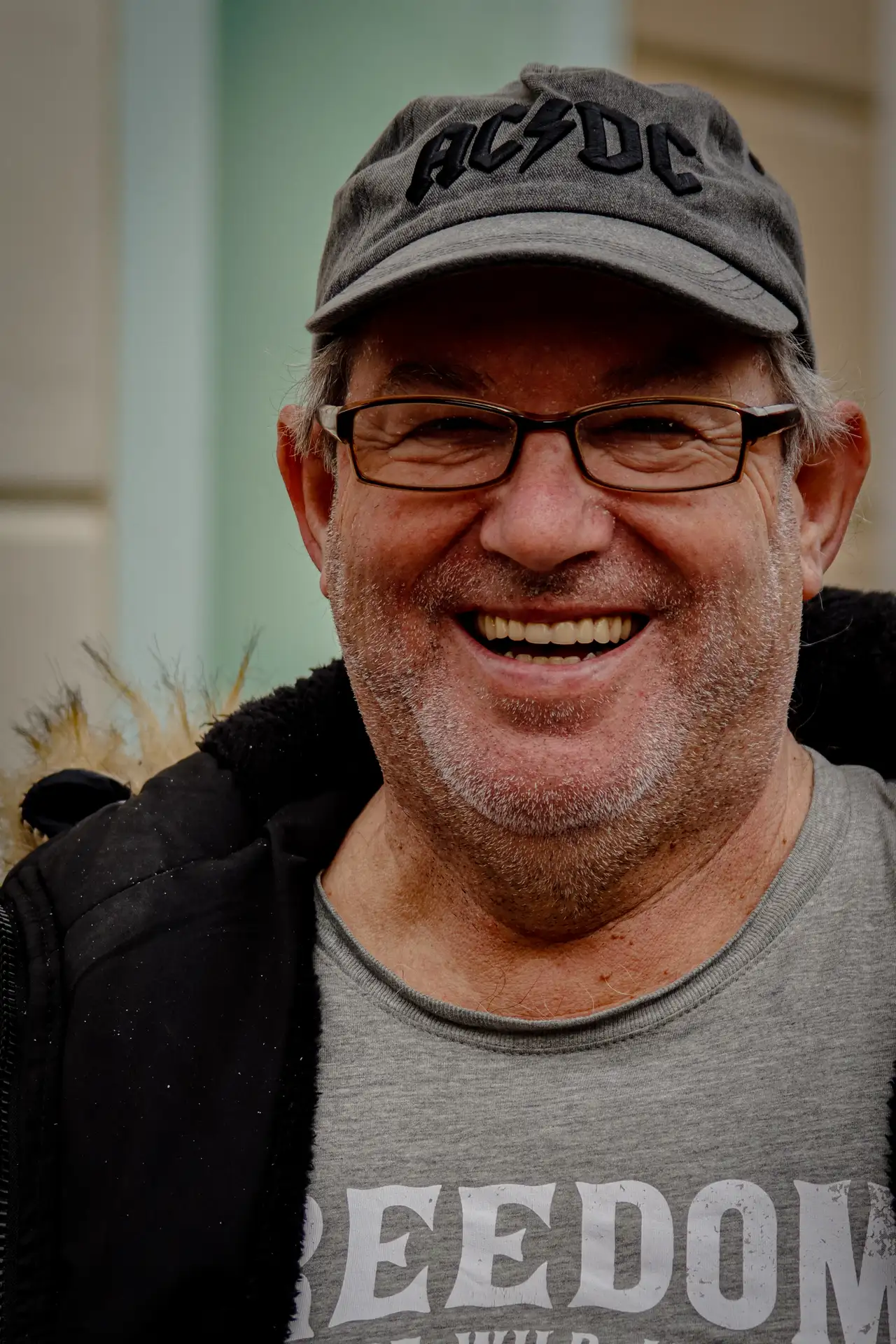 a man wearing a hat and glasses smiling