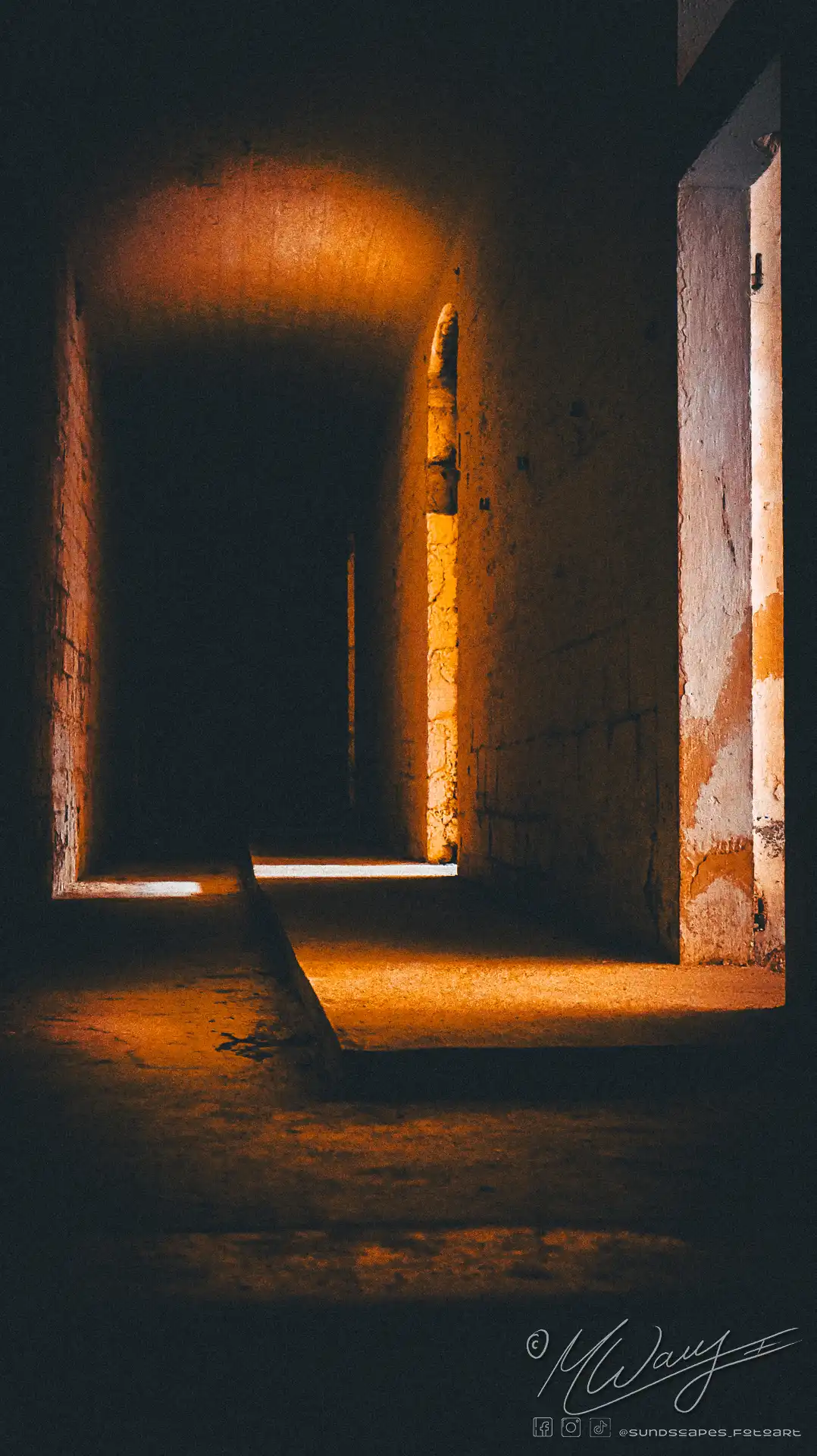 a dark hallway with light coming through the walls