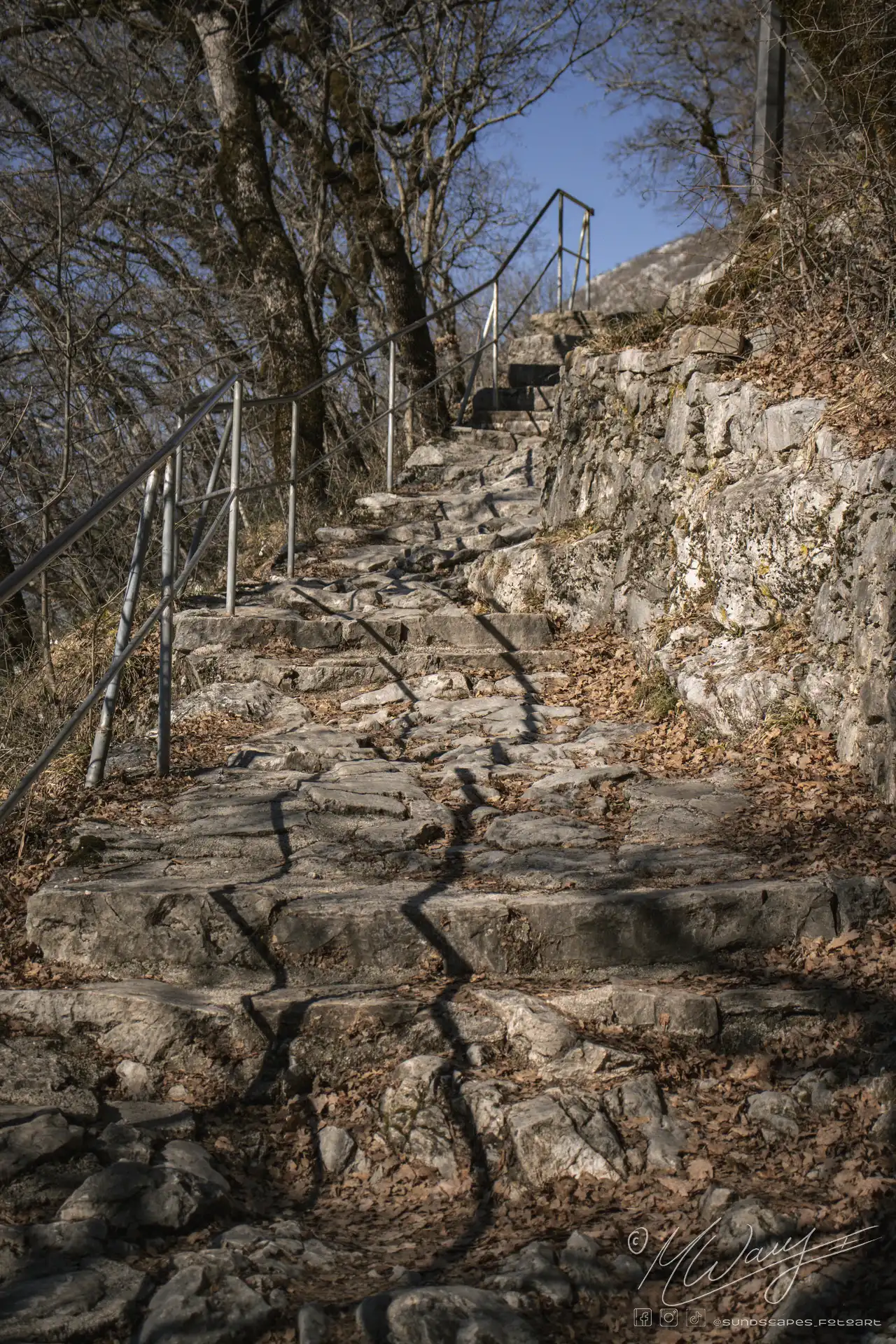 a stone stairs with metal railings