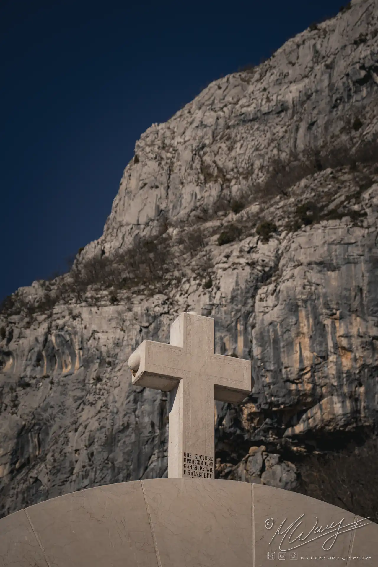 a cross on a stone post