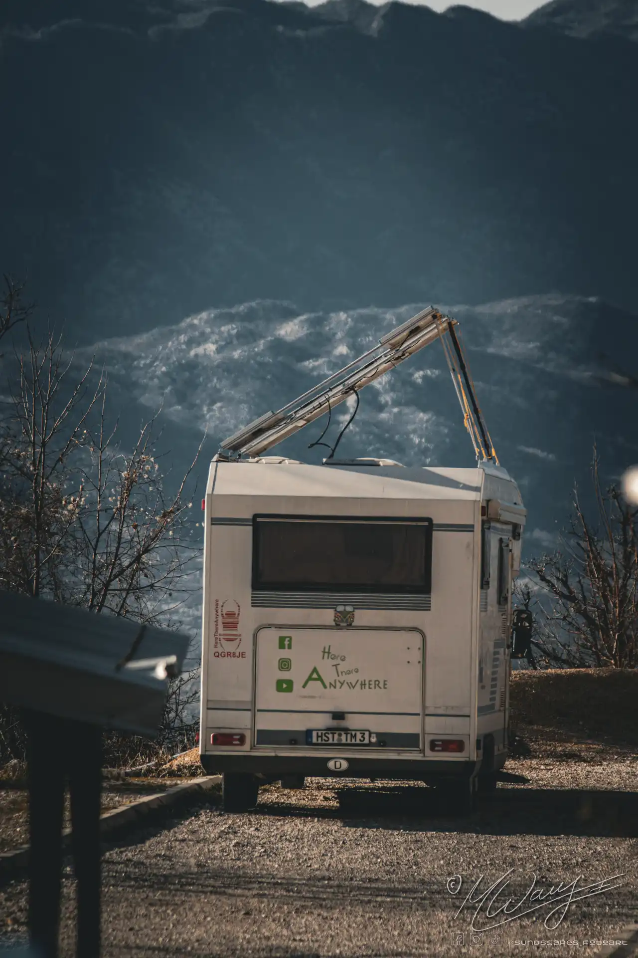 a white RV with solar panels open