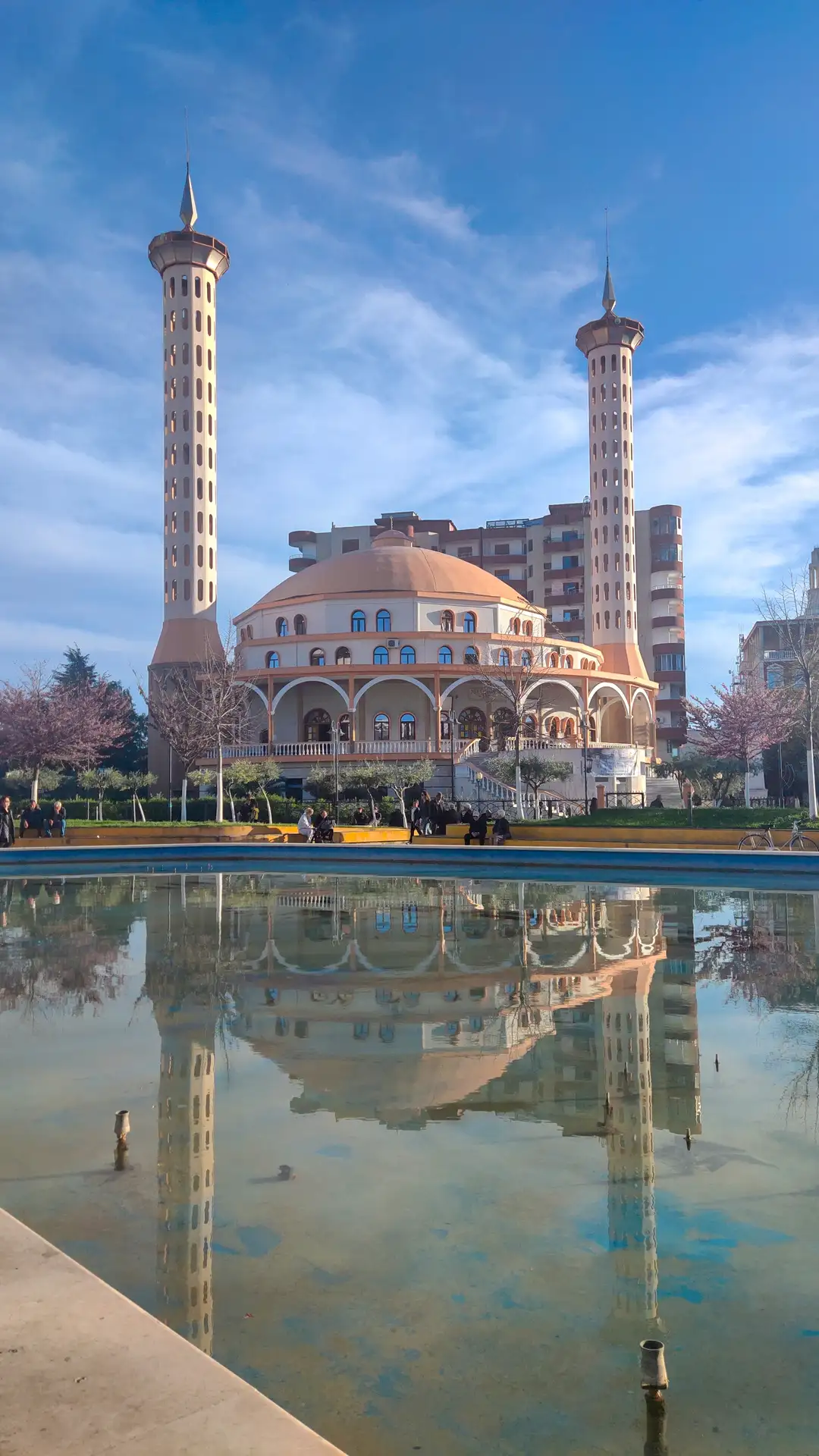 a mosche with towers and a pool of water