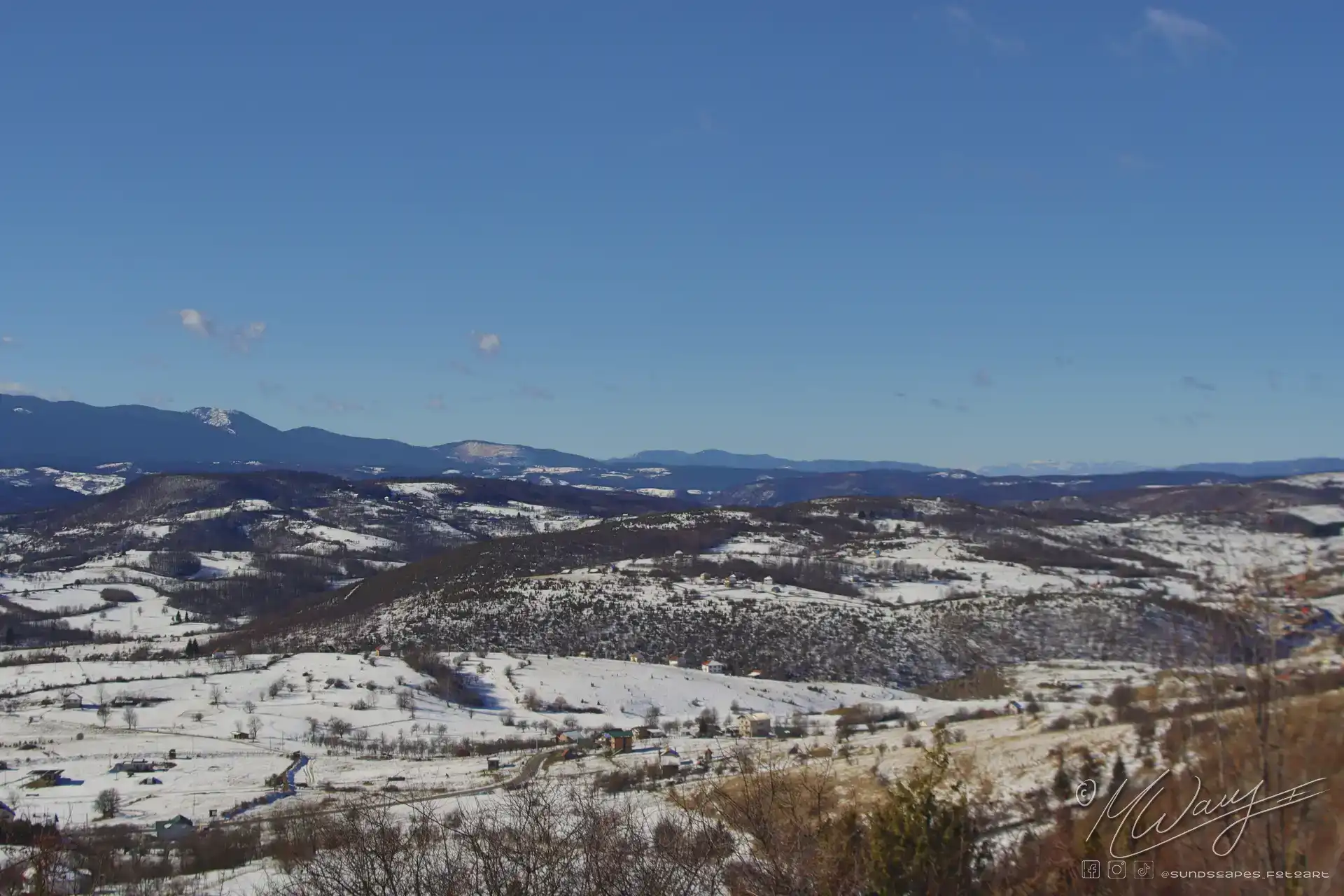 a snowy landscape with mountains and blue sky