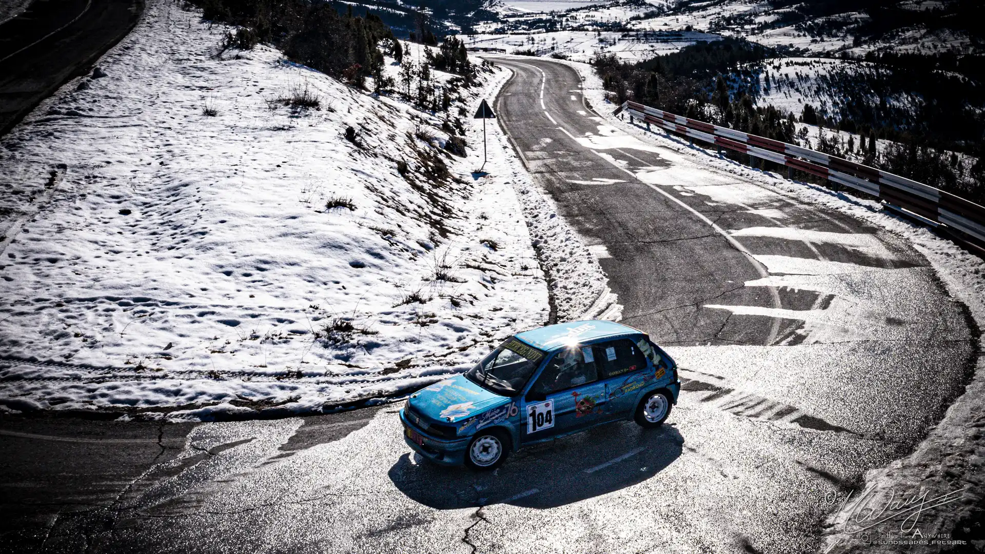 a car on a road with snow on the side