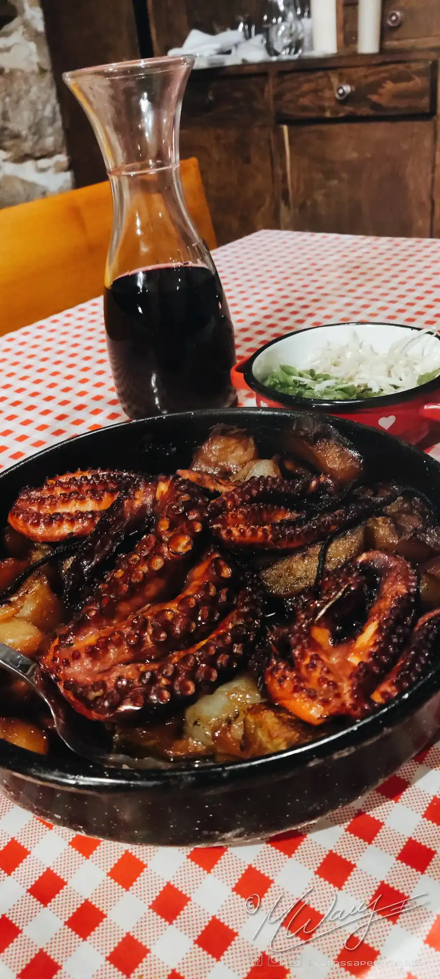 The Croatian dish Peka served with a pitcher of red wine