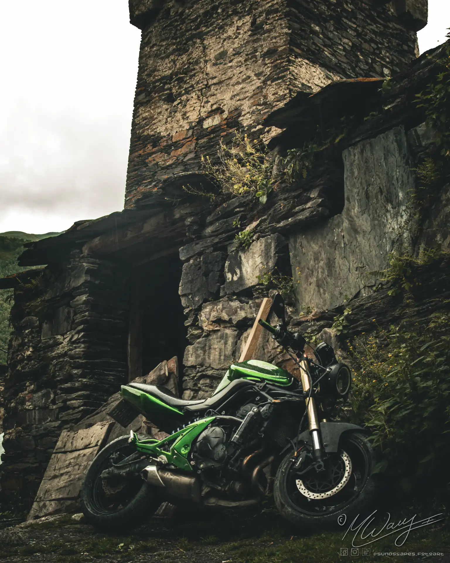 Ein modernes Motorrad vor einem alten Wehrturm in Uschguli Georgien