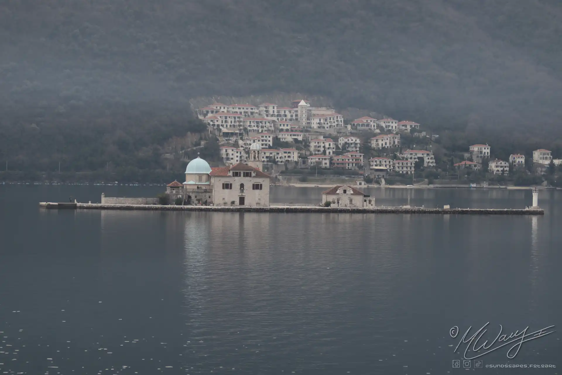 a city with red roofs and a body of water