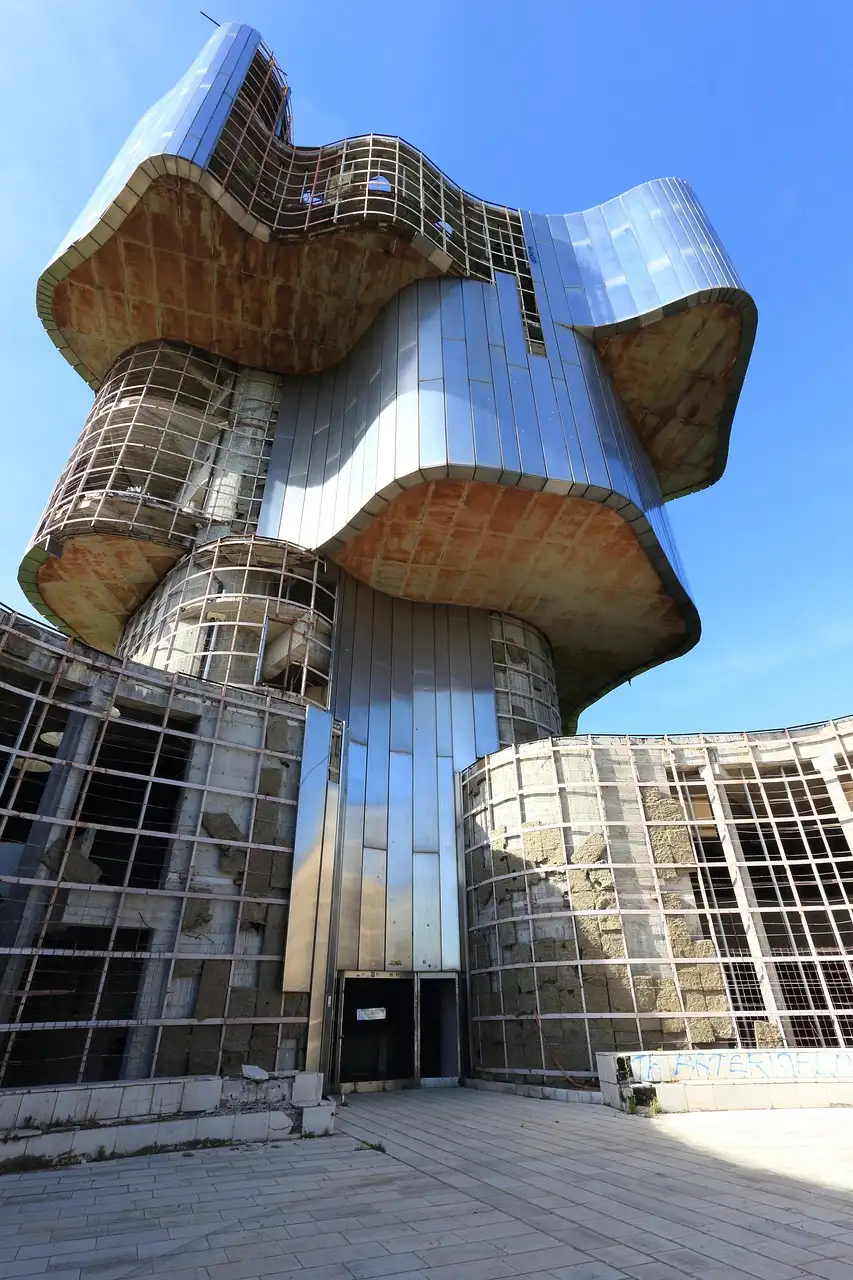 a decrepit abandoned futuristic building with a blue sky