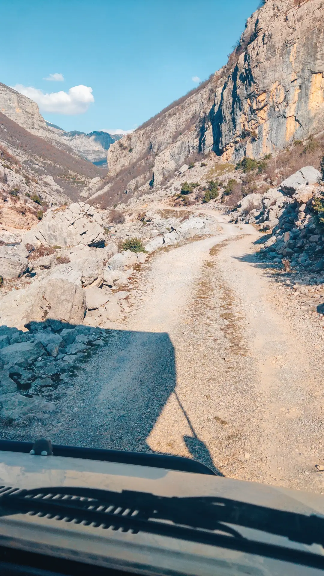 a dirt road with rocks and mountains in the background - Offroad im Camper