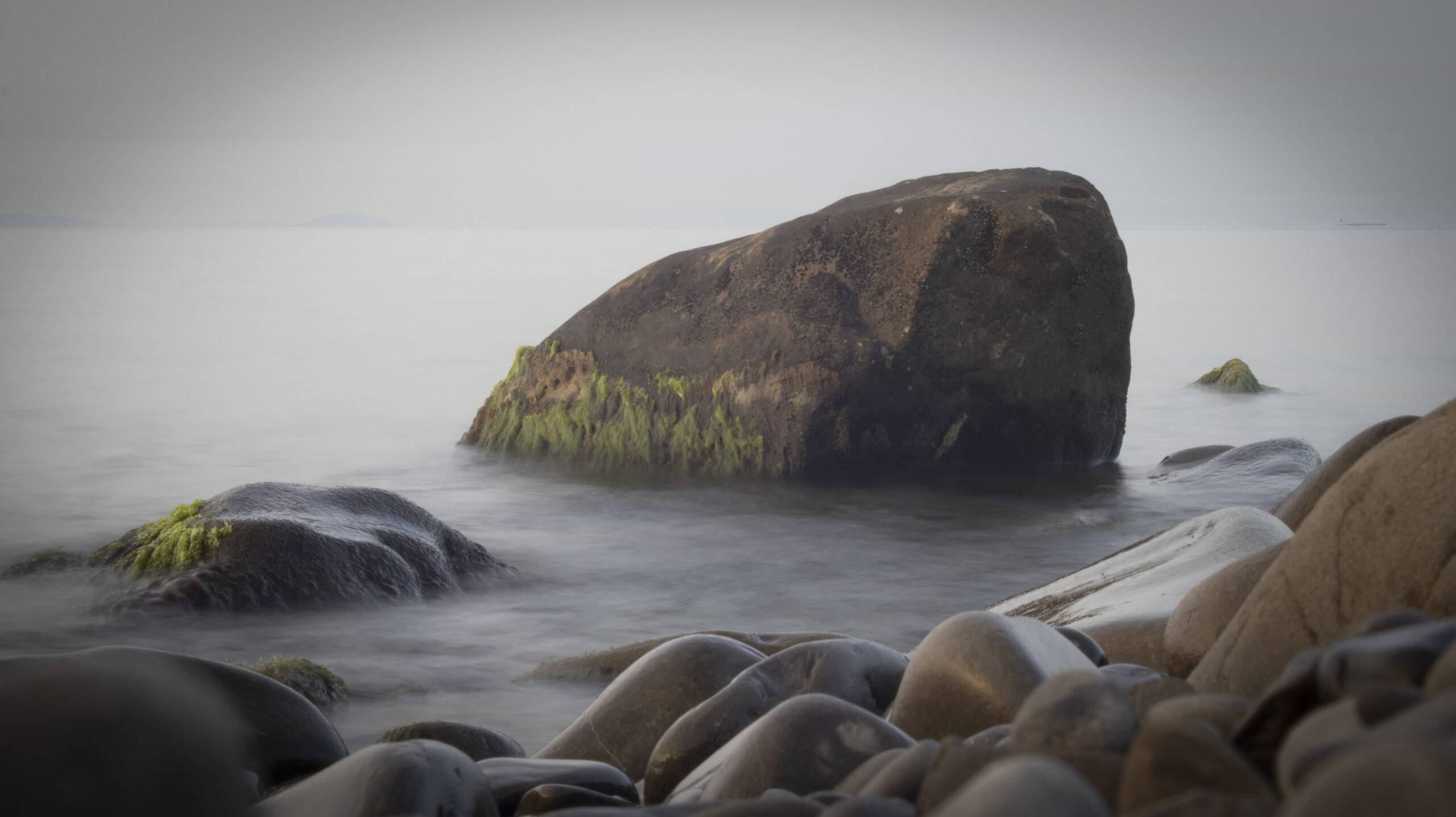 Acryl-Fotodruck zeigt Felsbrocken in Meerwasser, über dem der Nebel steht