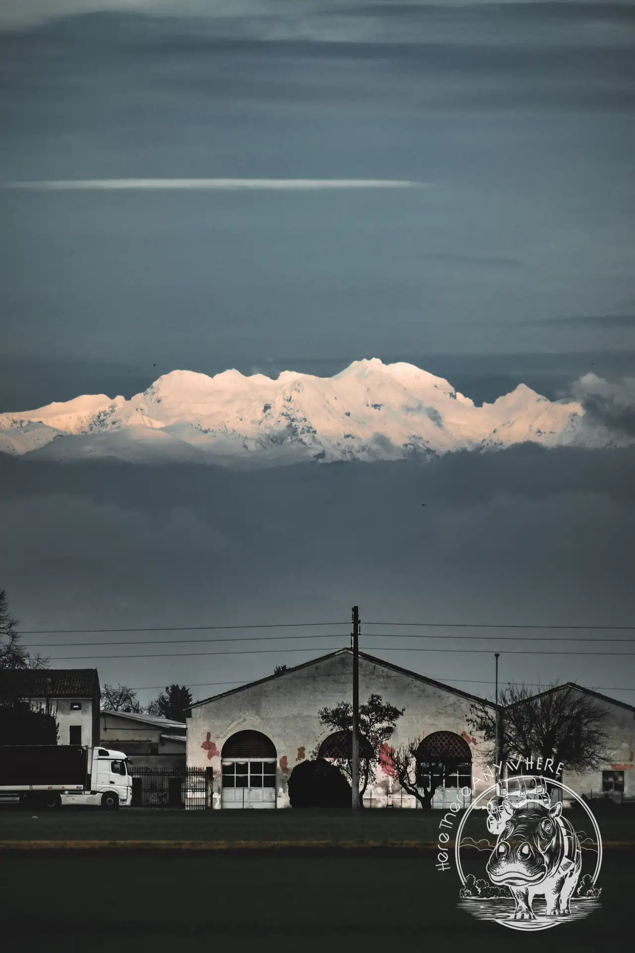 Ein weißes Haus vor blauem  Himmel mit einer Wolke. Reisefotografie in der Po-Ebene in Norditalien.