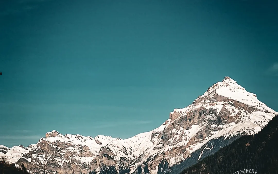 Schneebeckte Schweizer Berge auf unserem Roadtrip Tessin nach Italien im Vanlife